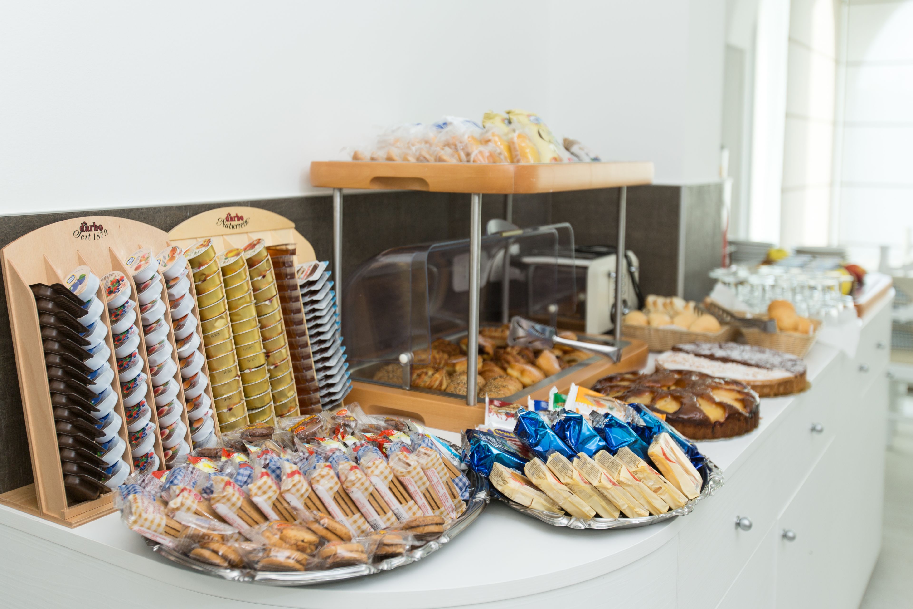 Un bufé con diversos alimentos, incluyendo pasteles, sándwiches y postres.