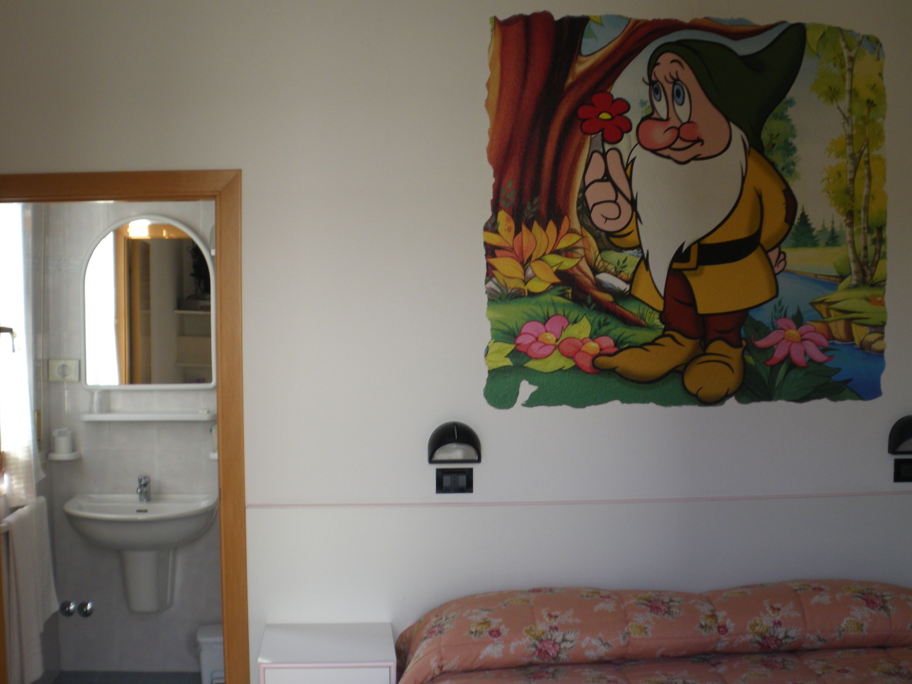 Un baño con lavabo, espejo e inodoro.