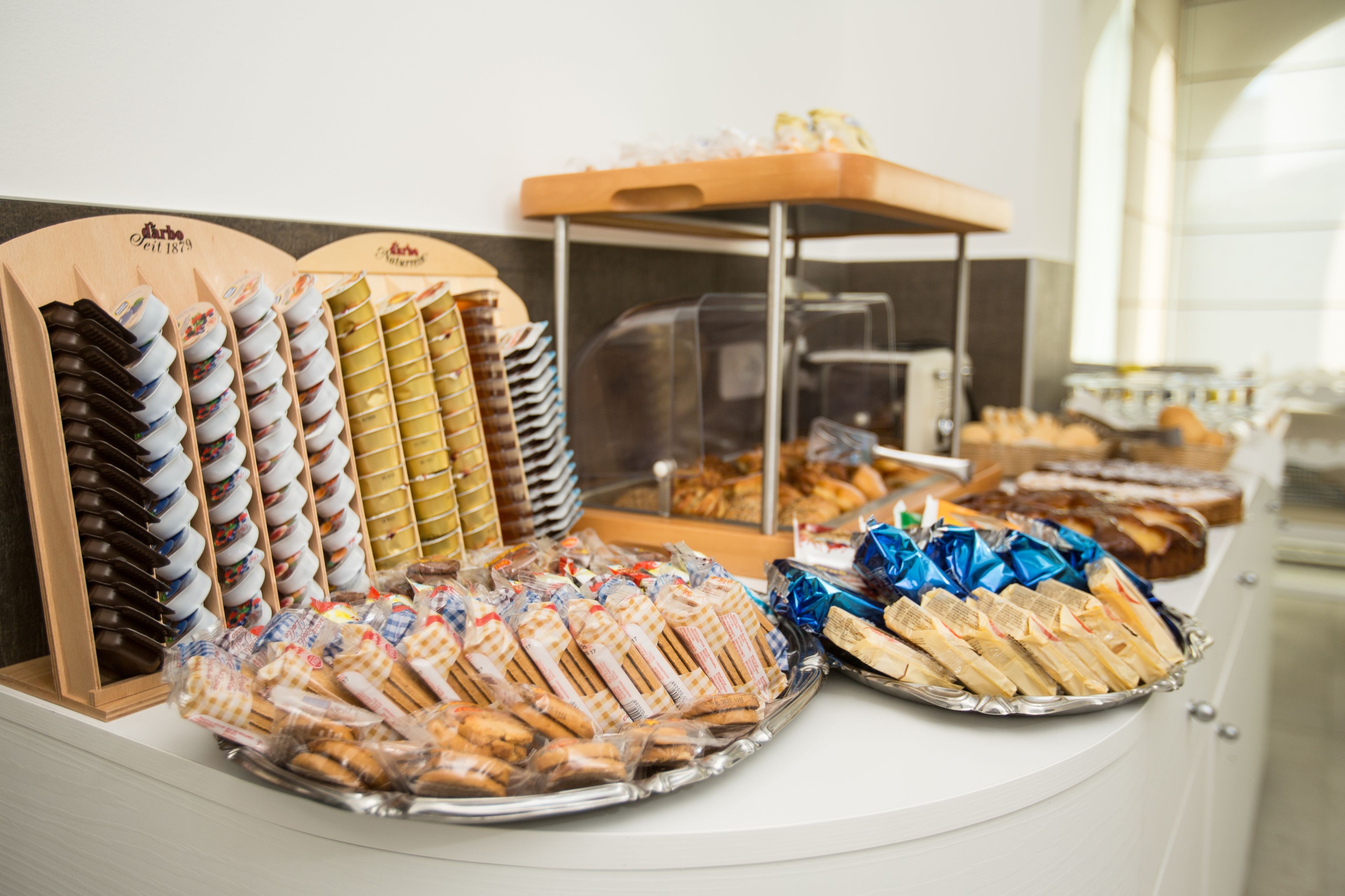 A buffet with various food items including pastries, sandwiches, and desserts.