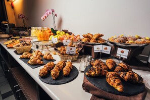 Un bufé con diversos pasteles y frutas.