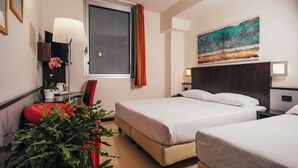 A hotel room with two beds, a large window with curtains, a painting on the wall, a red chair, a bedside table with a lamp, and a potted plant. - Euro Hotel (Imola)