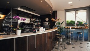 A bar area with a counter, stools, and a variety of bottles and glasses. - Euro Hotel (Imola)