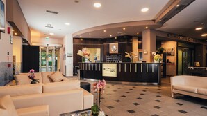 A hotel reception area with a modern design, featuring a reception desk, seating area, and a tiled floor. - Euro Hotel (Imola)