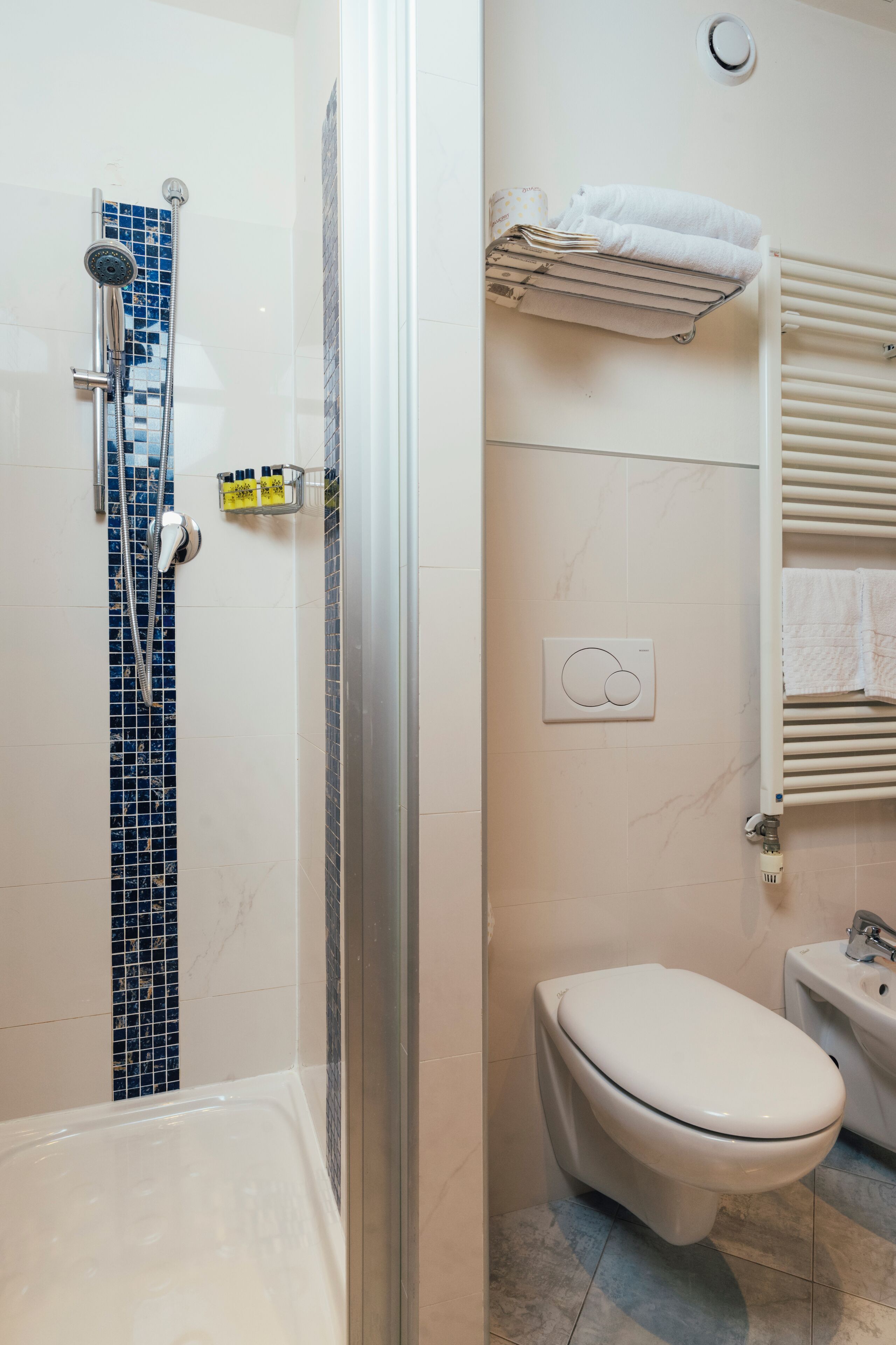 A bathroom with a shower, toilet, and sink.