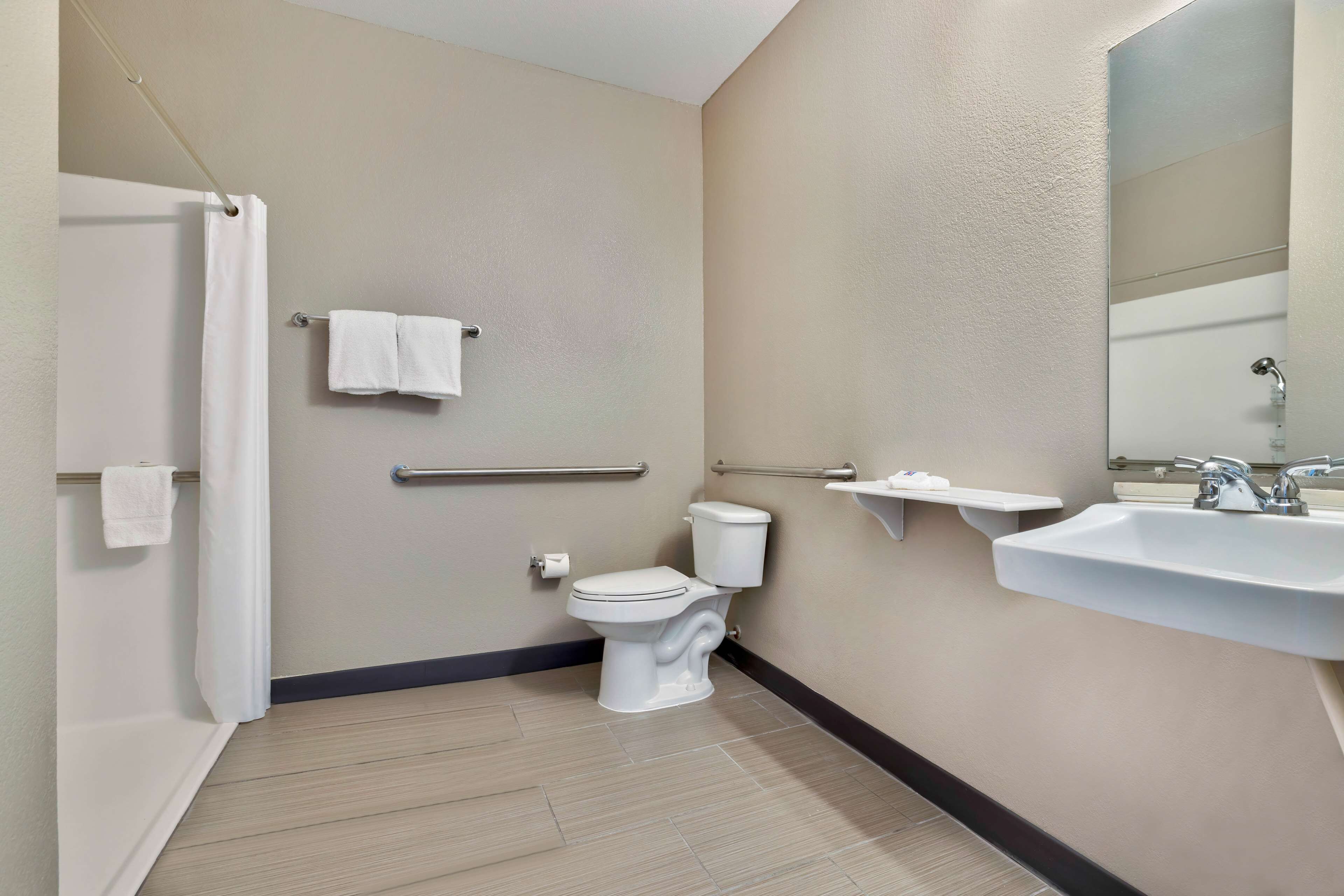 A modern bathroom with a toilet, sink, and shower.