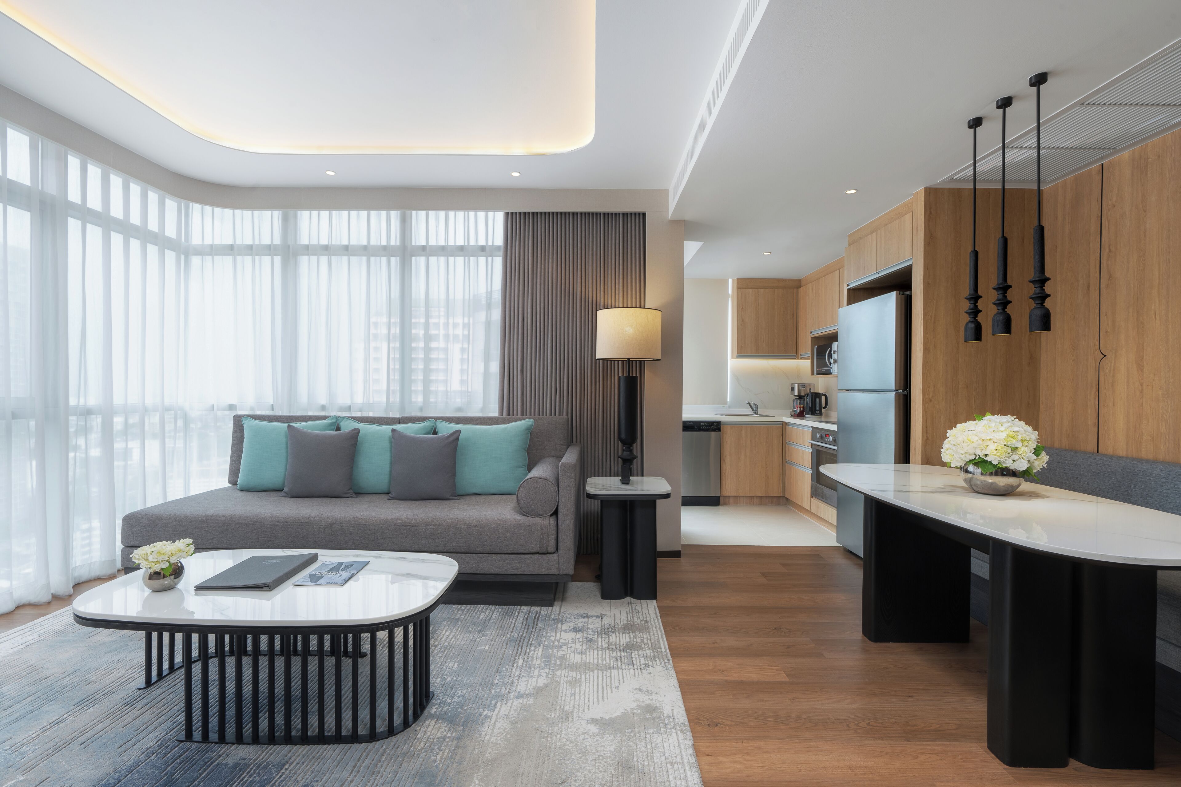 A modern living room with a sofa, coffee table, and a view of the city.