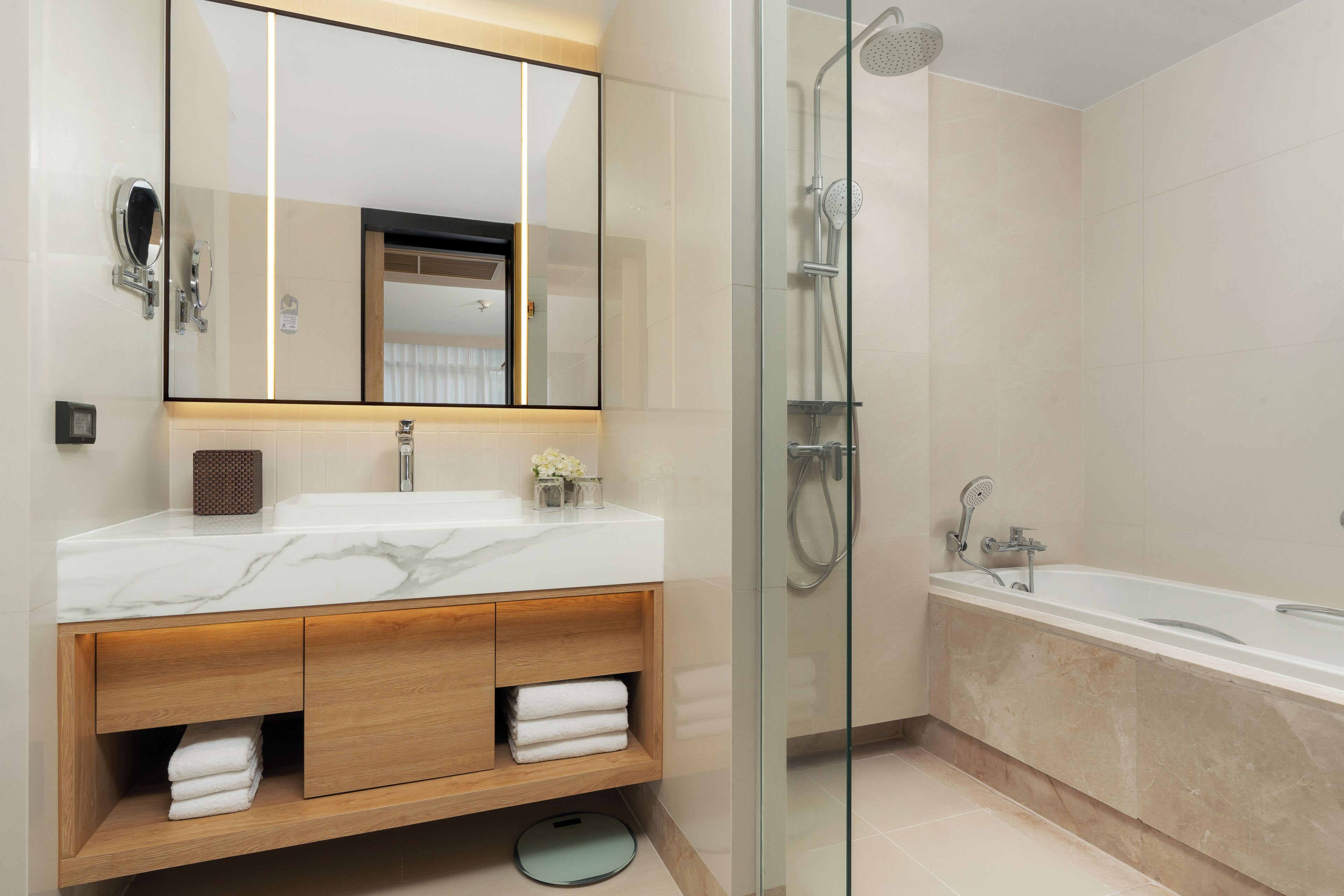 Une salle de bain moderne dotée d’une douche à parois de verre, d’une baignoire sur pieds et d’un meuble-lavabo avec un plan de travail en marbre.