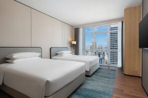 A hotel room with two beds, a large window with a city view, and a flat-screen TV. - Sathorn Vista, Bangkok - Marriott Executive Apartments (Bangkok)