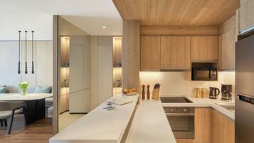 A modern kitchen with a central island, stainless steel appliances, and wooden cabinetry.