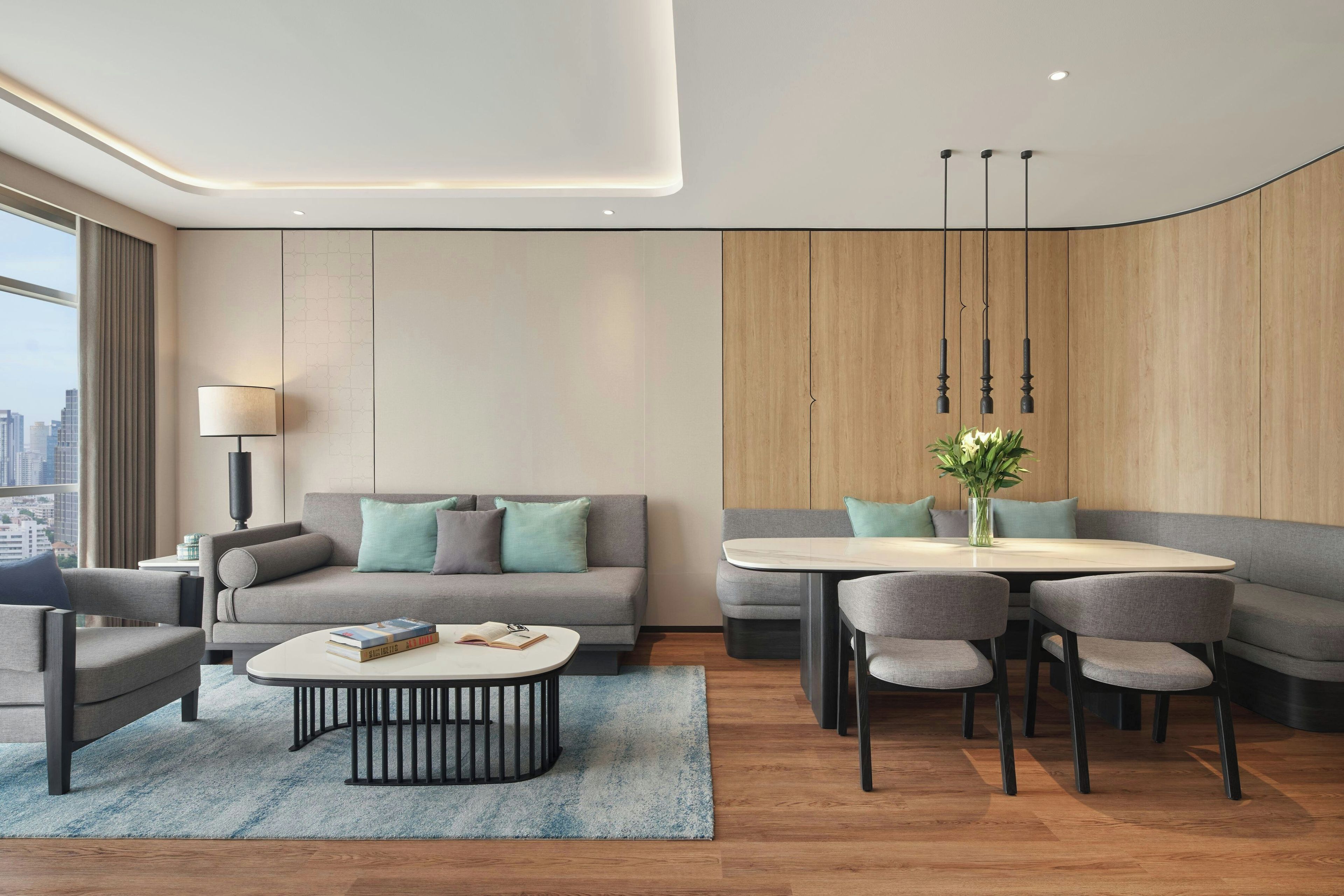 Ein modernes Wohnzimmer mit einer Couch, einem Couchtisch und einem Essbereich mit Stühlen.