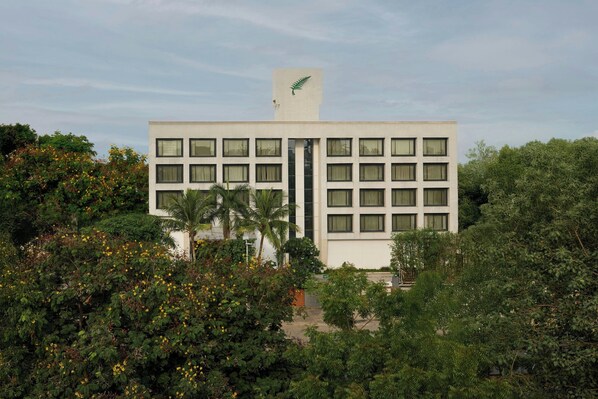 A modern building with a flat roof, rectangular windows, and a logo on the top.
