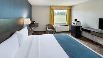 Een hotelkamer met een bed, een bureau, een stoel, een televisietoestel en een raam met gordijnen.