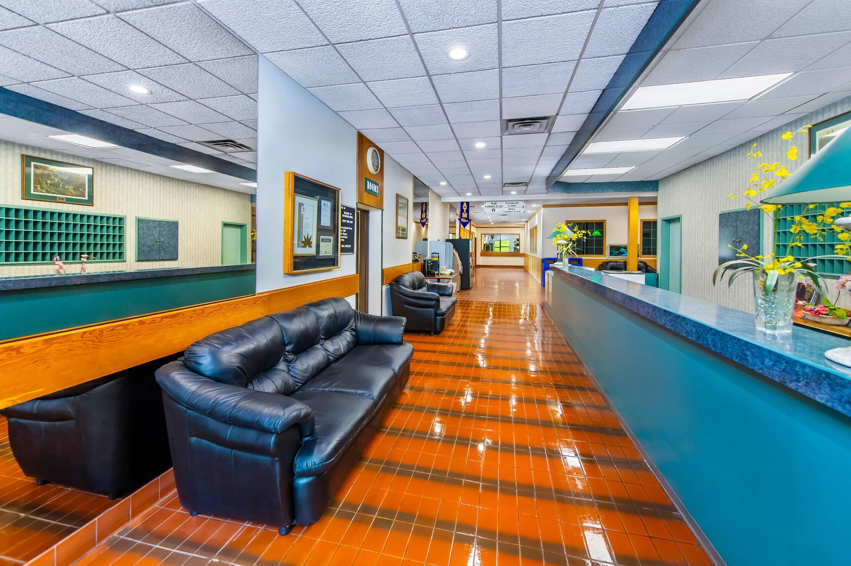 A hotel lobby with a reception desk, seating area, and a blue accent wall.