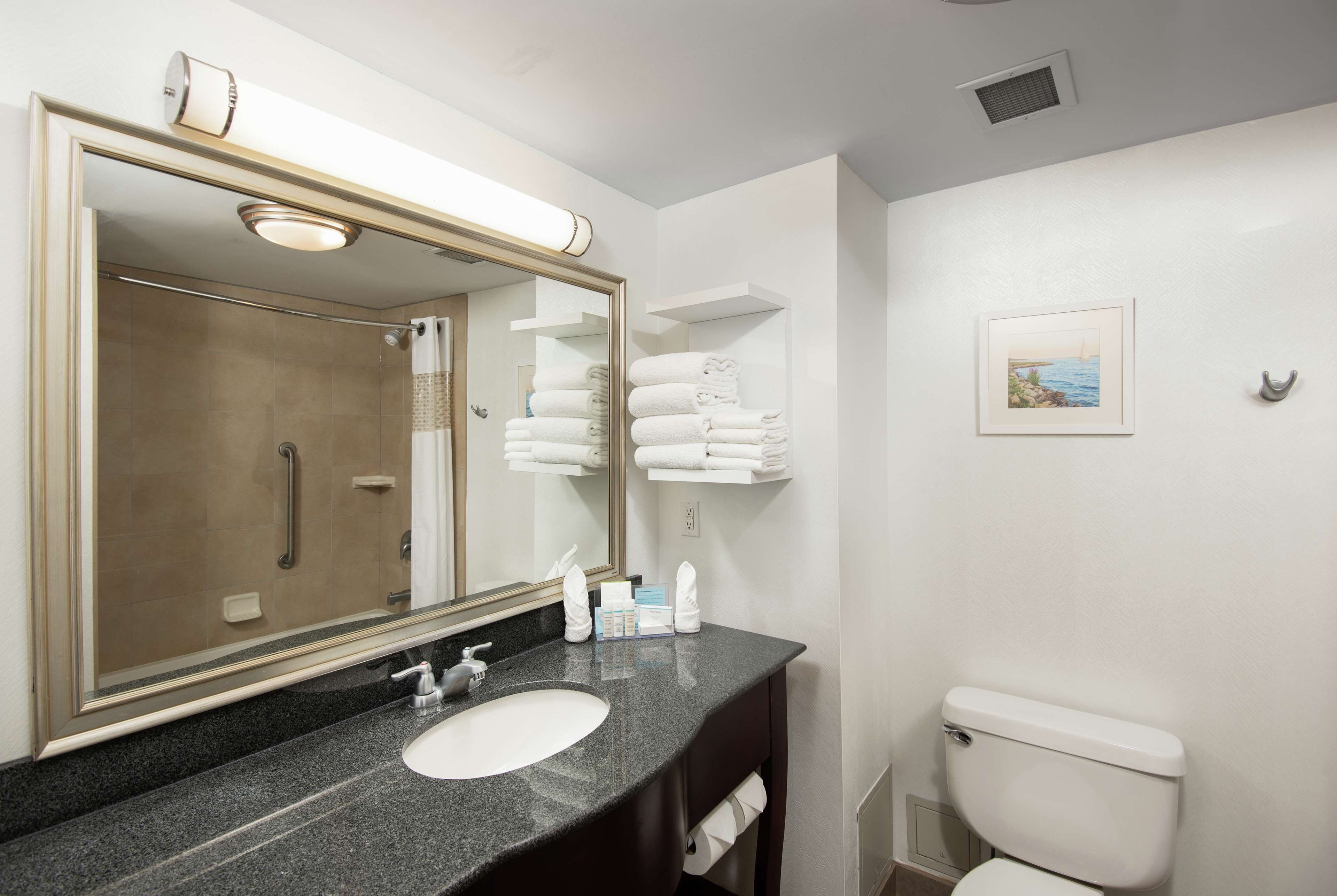 A bathroom with a sink, mirror, towel rack, and toilet.