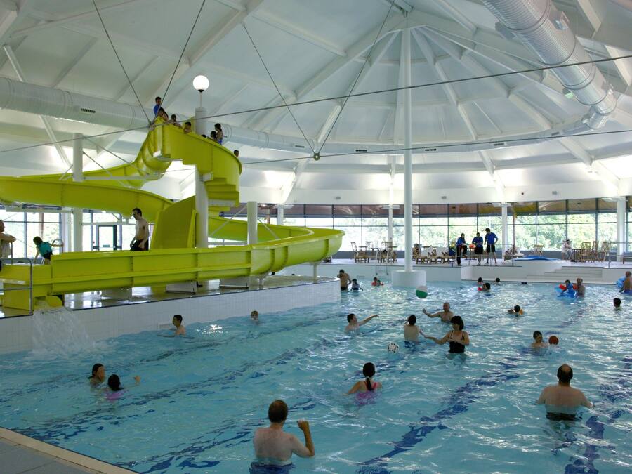 Una piscina cubierta, tumbonas