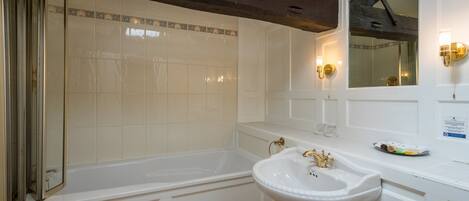 A bathroom with a bathtub, a sink, and a shower.