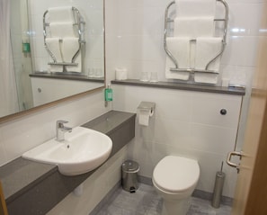 A modern bathroom with a sink, mirror, toilet, and towel rack. - Westlodge Hotel (Bantry)
