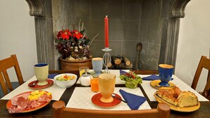 A dining table set with plates of food, glasses, and a candle. - Hotel Vasari (Florence)