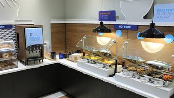 A breakfast buffet with various food options and a coffee machine.