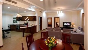 Una sala moderna con sofá, televisor y comedor.