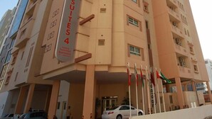 Un edificio de varios pisos con un letrero que dice "RAMEE SUITES 4", indicando apartamentos amueblados de lujo.