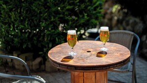 Two glasses of beer on a round wooden table with metal chairs. - Hotel Vissenbjerg Storkro (Vissenbjerg)