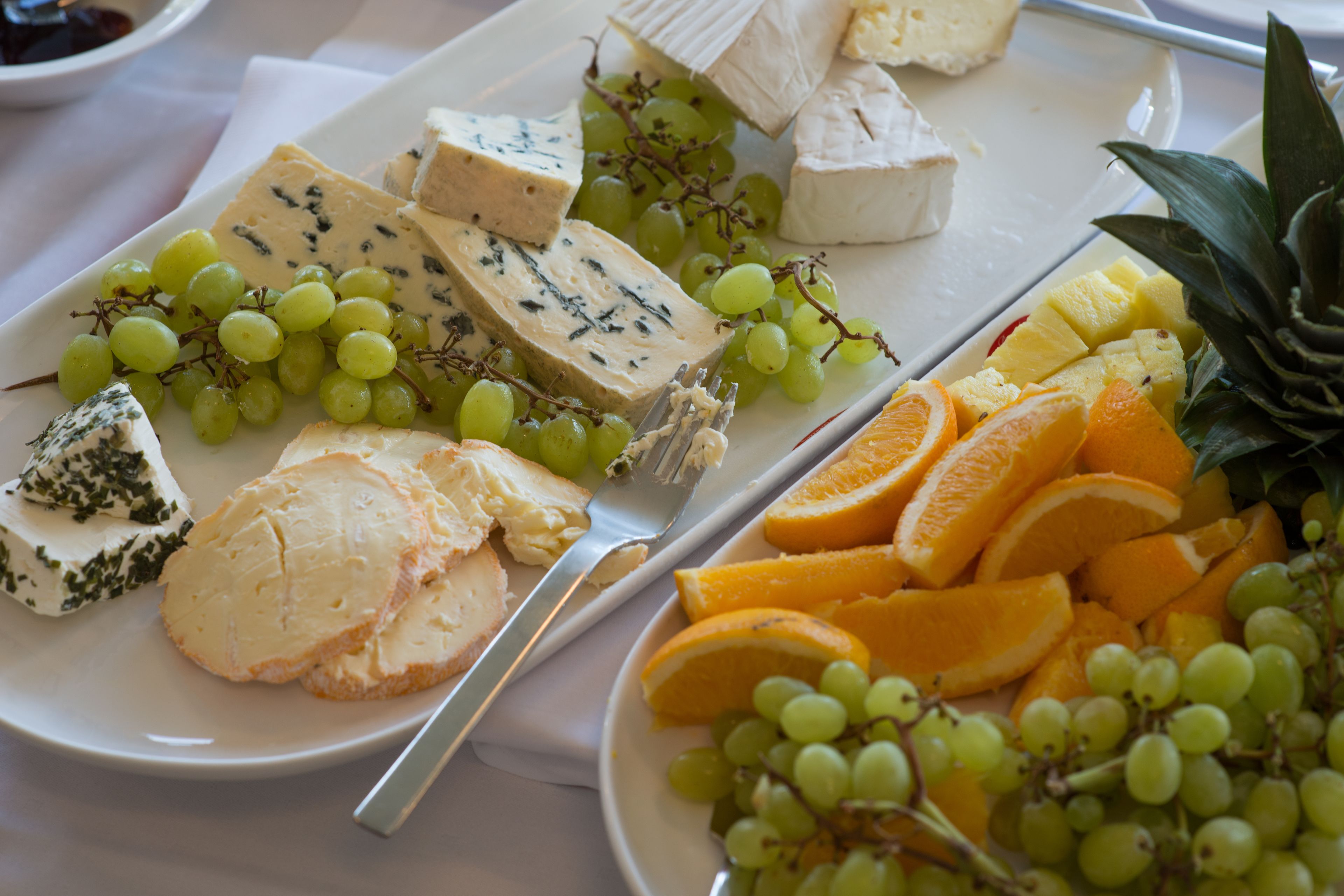 A platter of assorted cheeses and fruits.