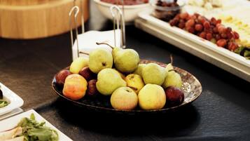 A table with a variety of fruits and vegetables, including apples and grapes.