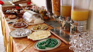 A buffet with various food items and beverages. - Hotel Damanse (Ricadi)