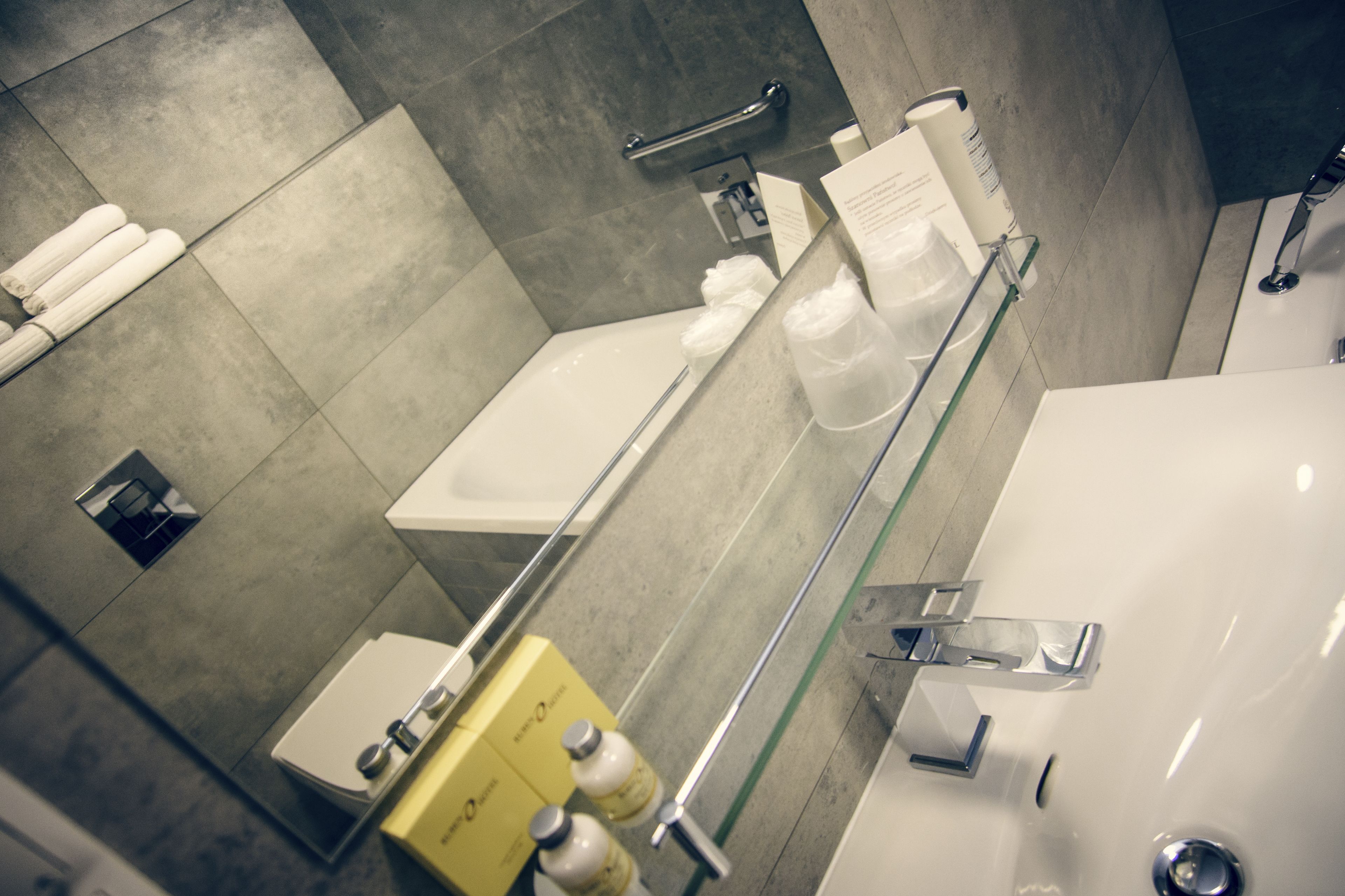 A modern bathroom with a glass shower enclosure, a white sink, and a toilet.