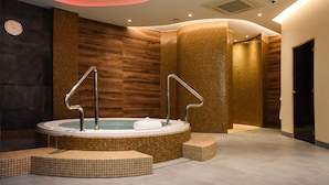 A modern spa area with a hot tub, wooden walls, and a clock on the left. - Ruben Hotel (Zielona Gora)