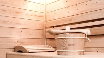 Un sauna de madera con un balde y un banco de madera.