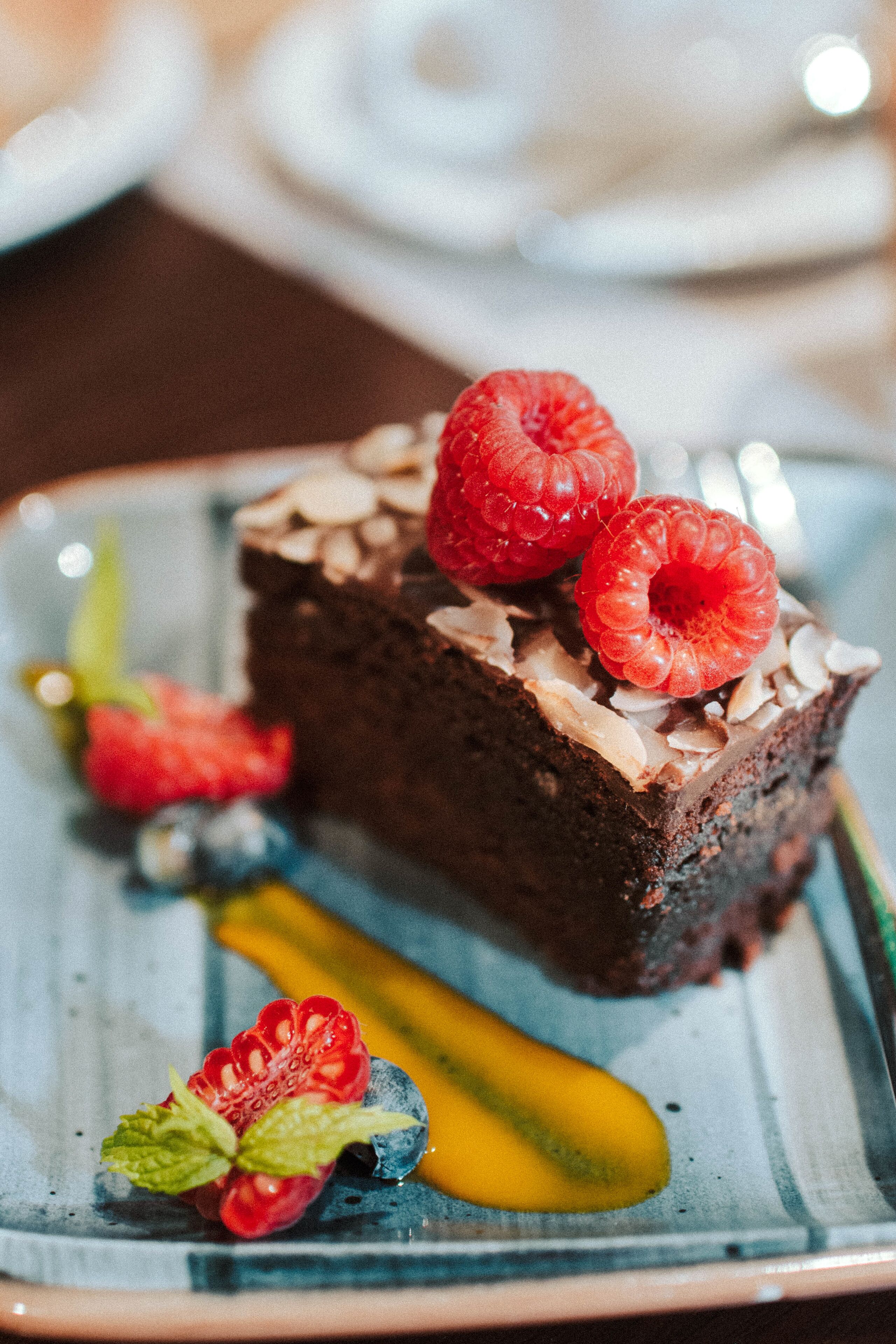 Un postre con frambuesas y una porción de pastel en un plato.