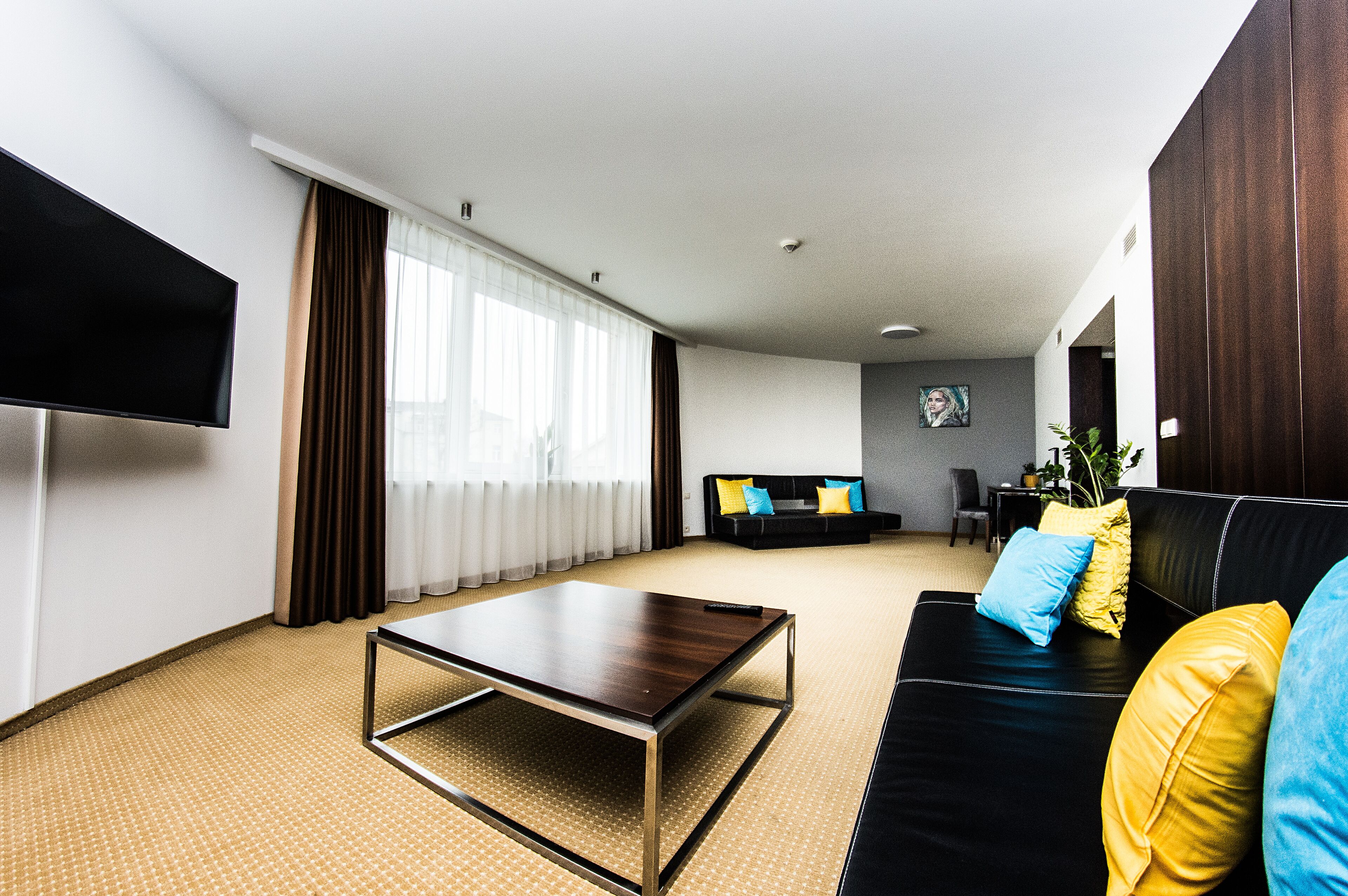 A modern living room with a sofa, a coffee table, and a TV.