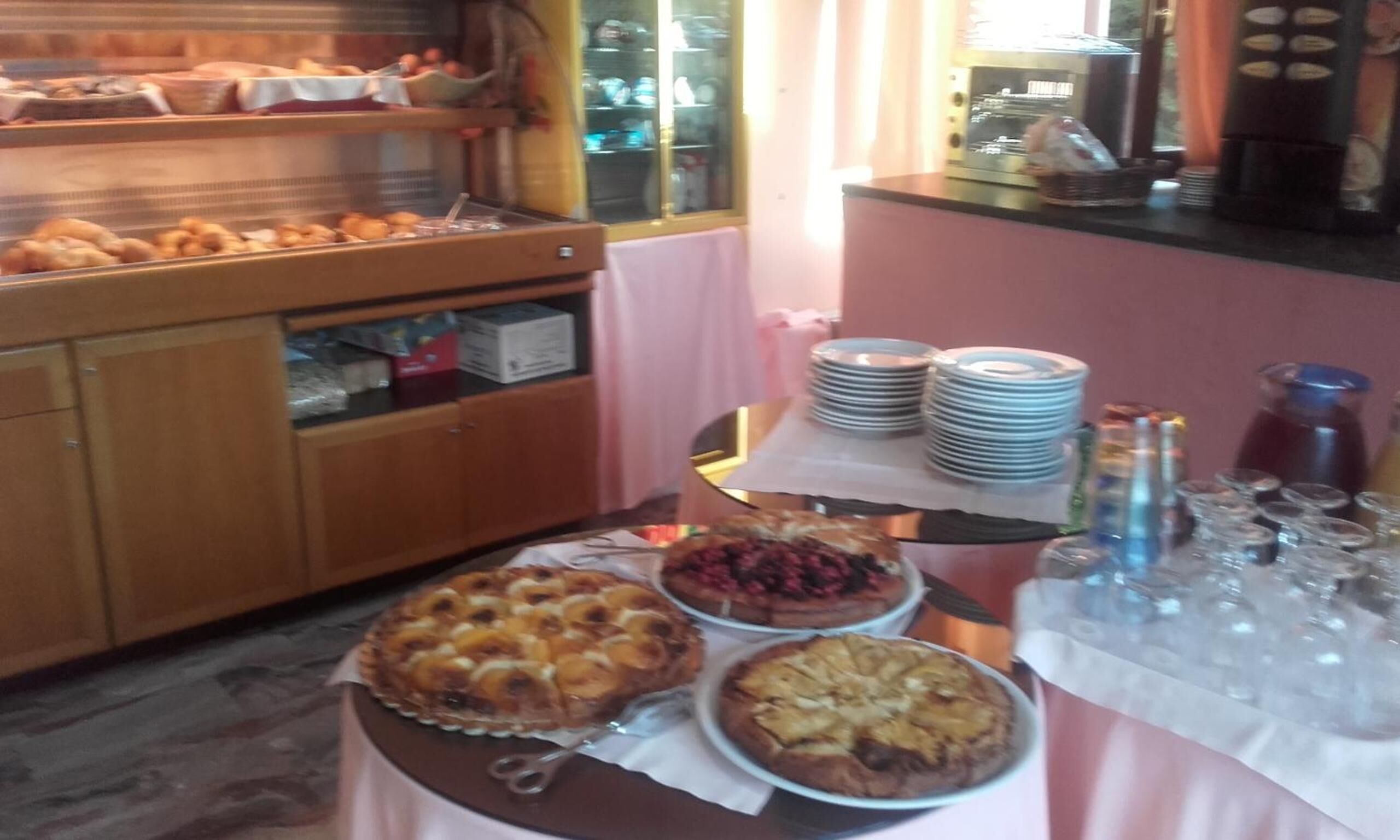 A buffet setup with various baked goods and a coffee machine.