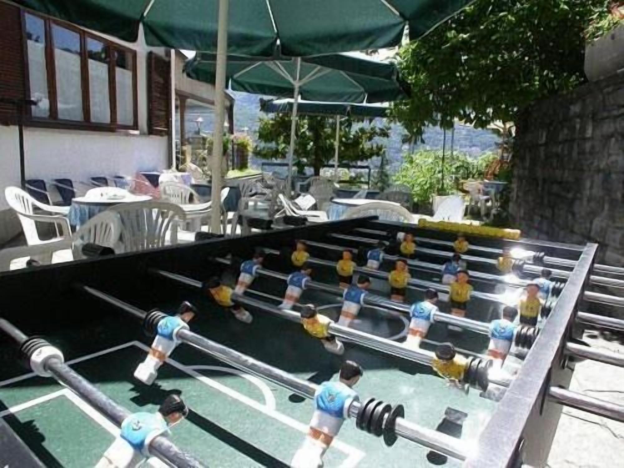 Een tafelvoetbaltafel in een openlucht setting, met stoelen en parasols.