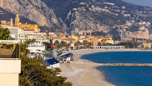 A coastal town with a prominent casino, a beach, and buildings on a hillside.