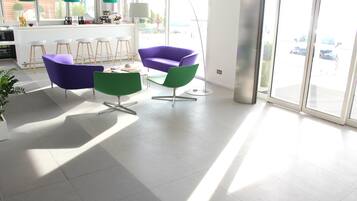 Una cocina moderna con taburetes de bar, una silla morada y una silla verde.