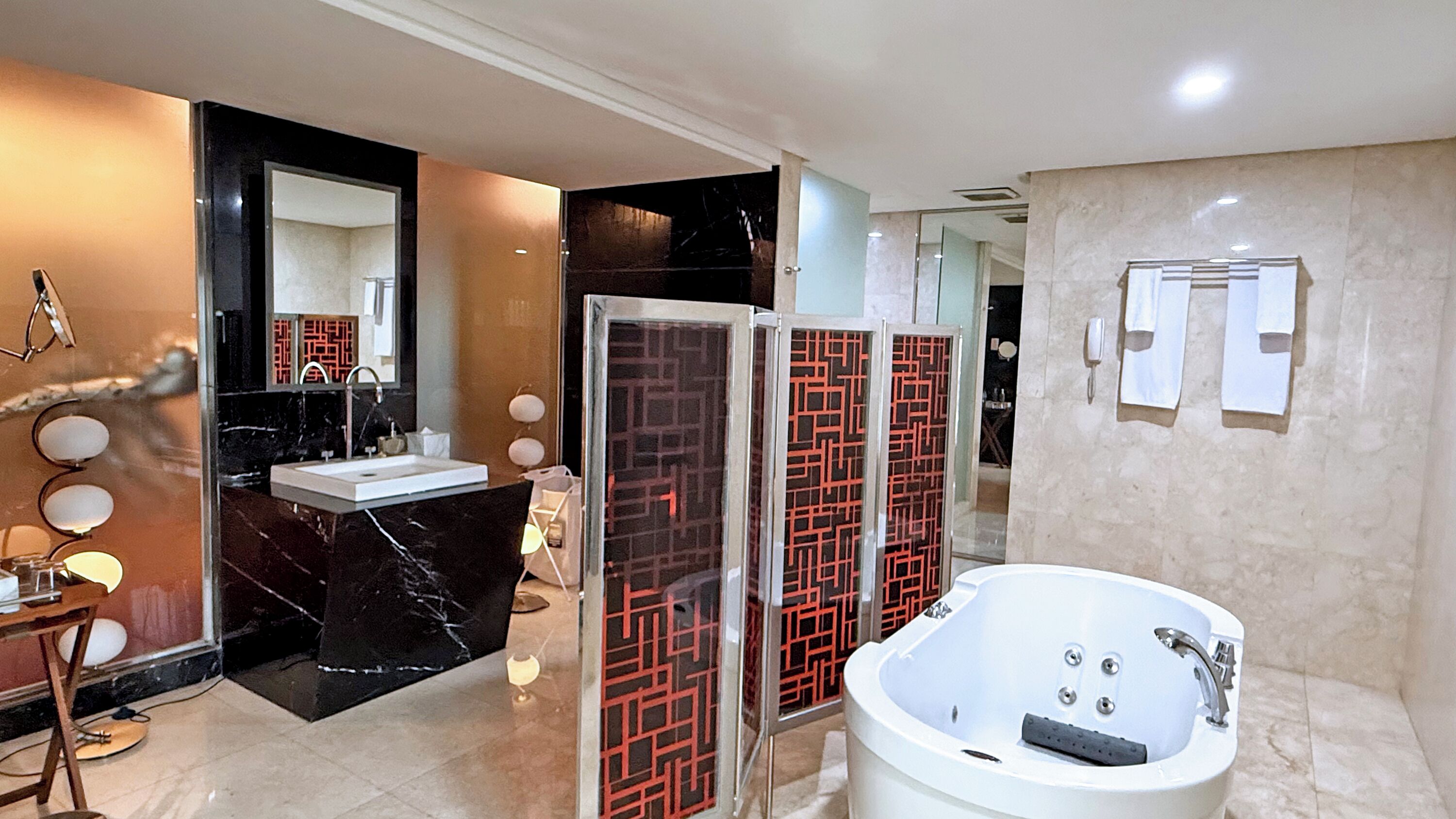 Un baño moderno con una bañera grande, zona de ducha separada y tocador con espejo.