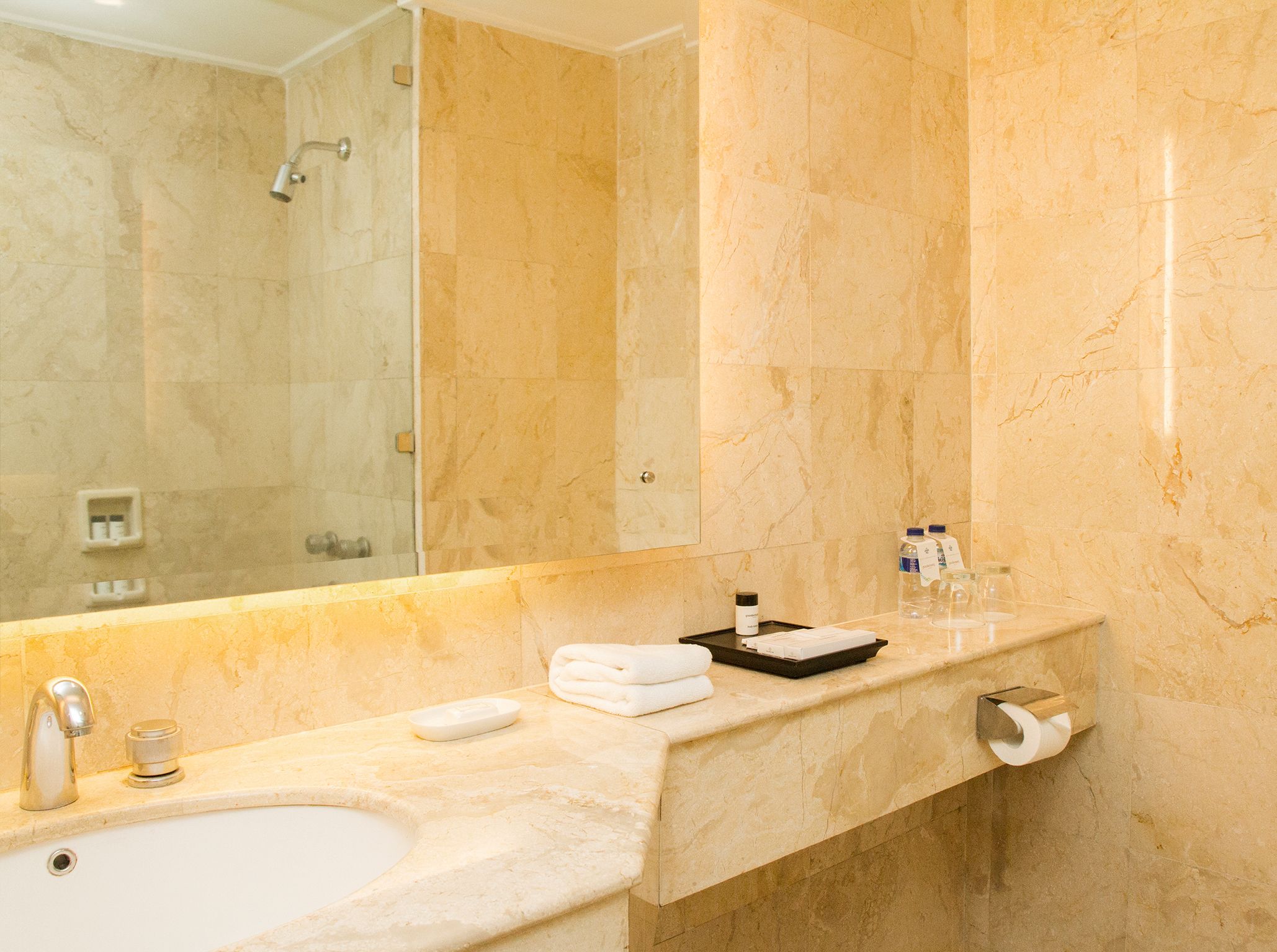 A bathroom with a sink, mirror, and shower.