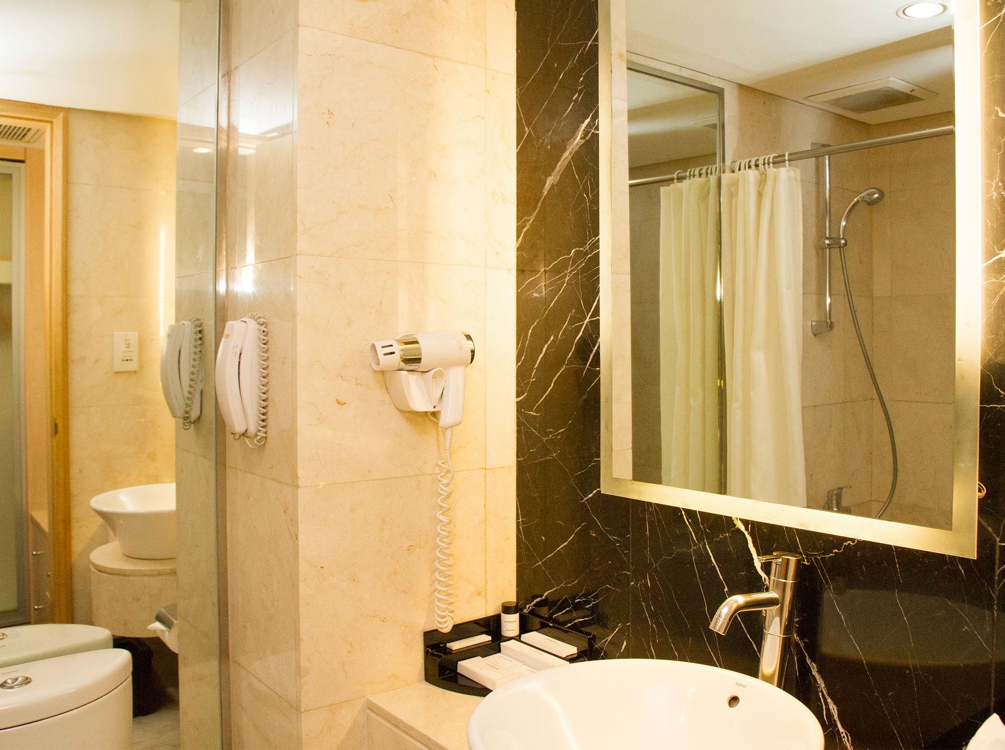 A bathroom with a toilet, sink, and a shower area.