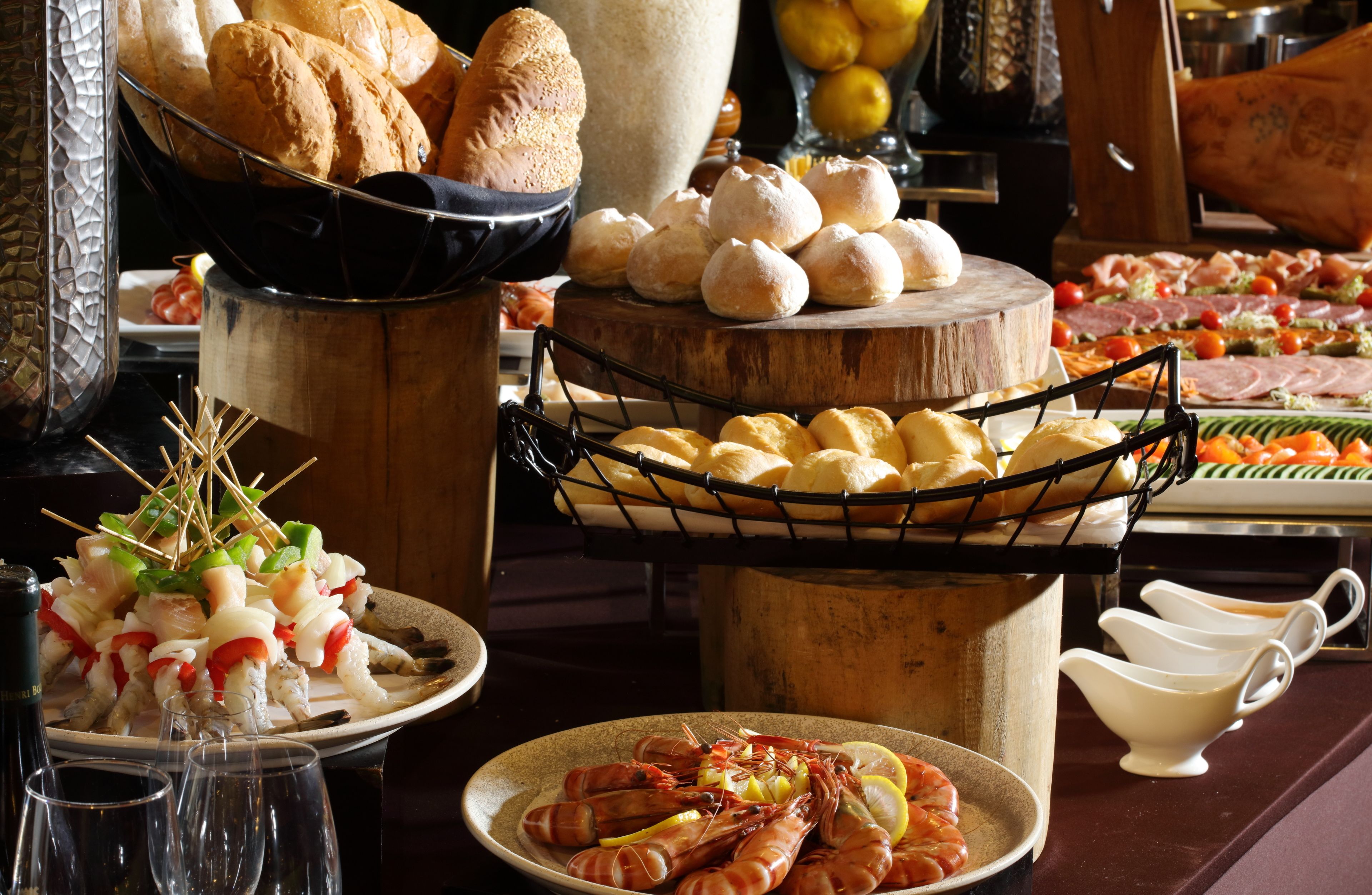 Un buffet proposant une variété de plats, notamment du pain, des pâtisseries et des fruits de mer.