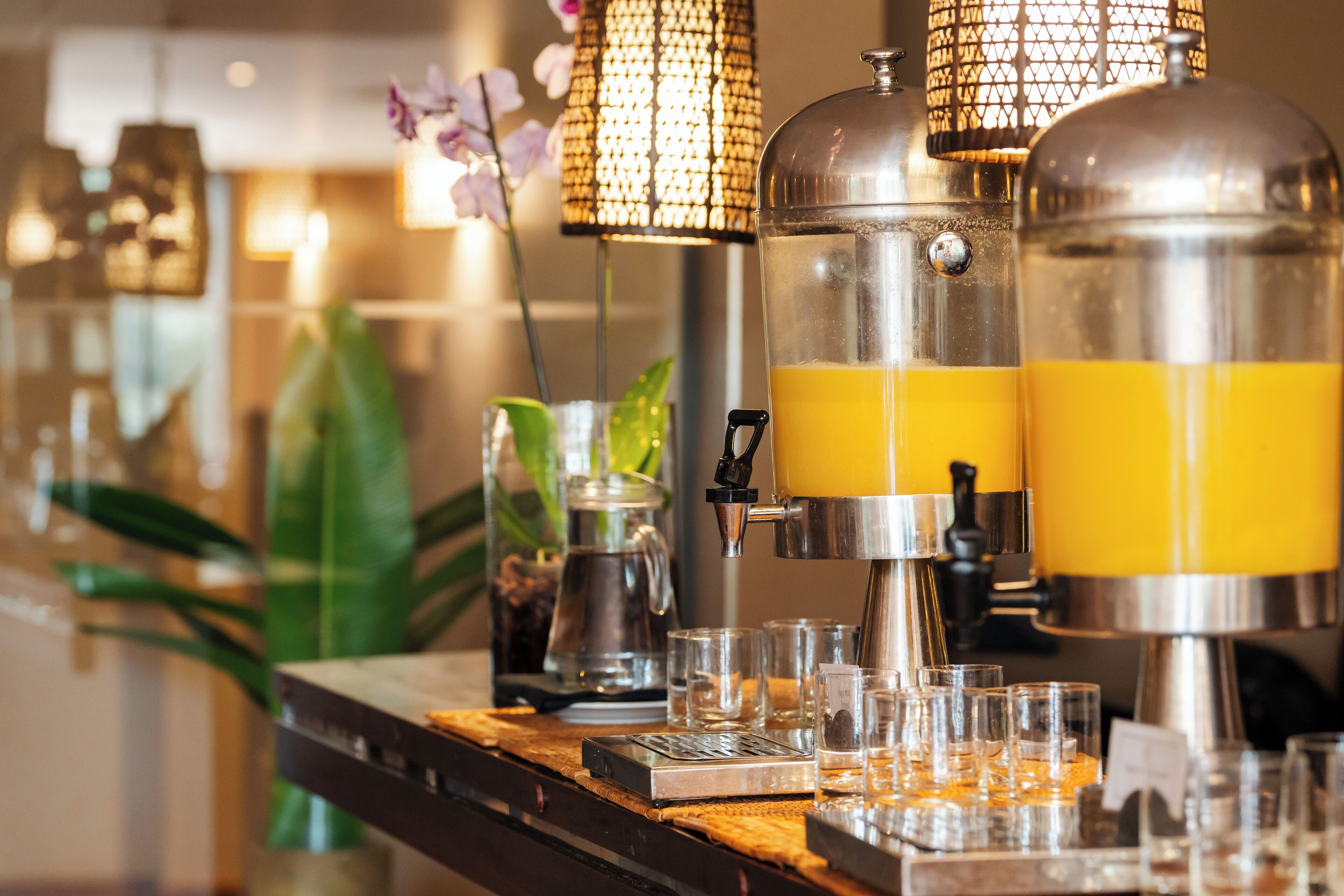 A bar area with a coffee machine, glasses, and a decorative lamp.