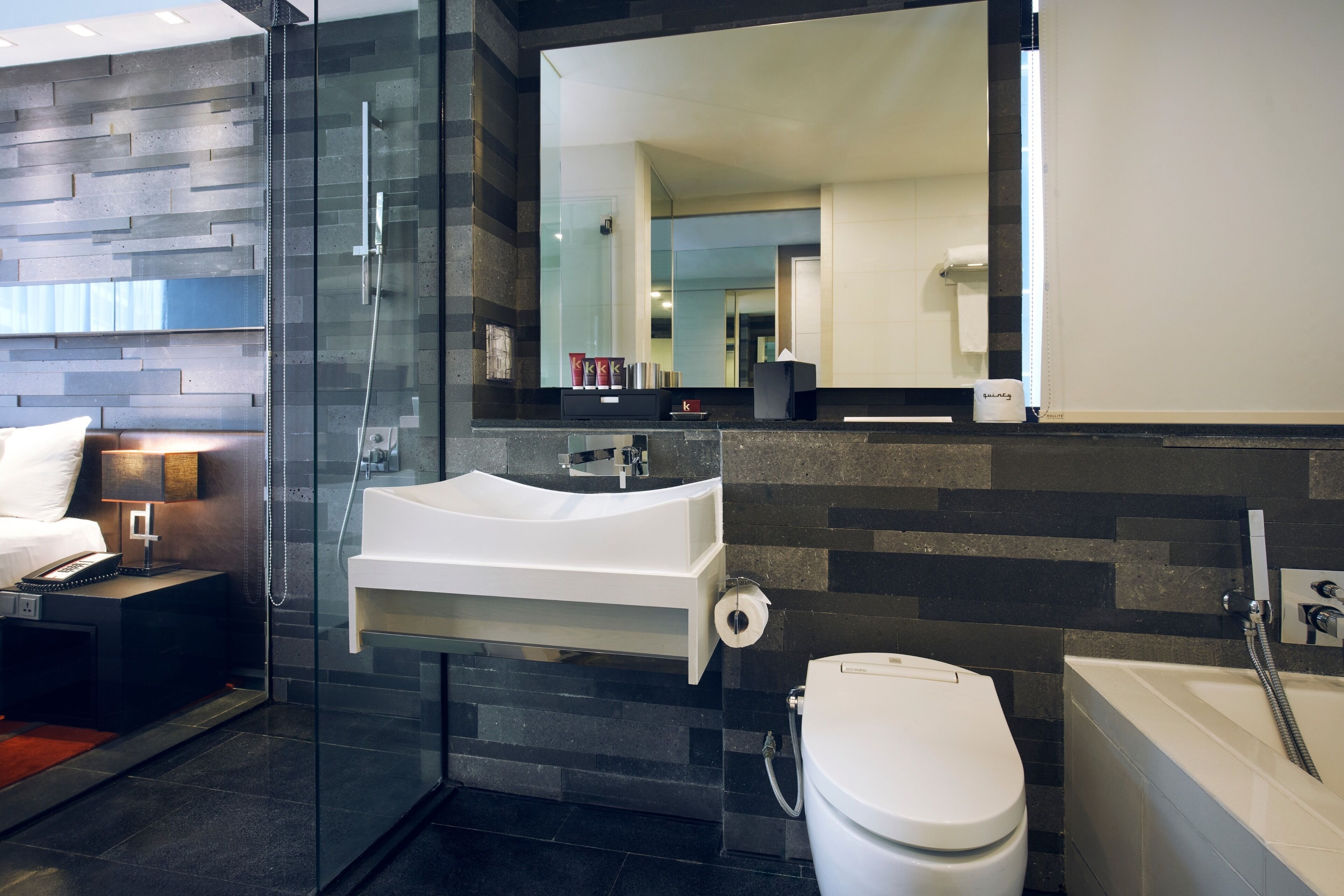 A modern bathroom with a glass-enclosed shower, a white sink, and a bathtub.