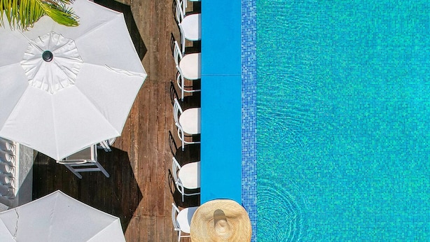 A pool area with multiple white umbrellas and lounge chairs. - S Hotel Kingston (Kingston)