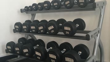 A multi-tiered dumbbell rack with various weights labeled 'Intek'.