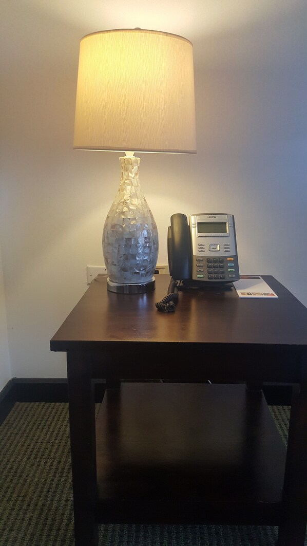 A small table with a lamp, a telephone, and a decorative glass object. - S Hotel Kingston (Kingston)