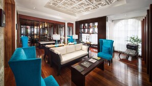 A spacious living area with a sofa, two armchairs, a coffee table, and a bookshelf. - S Hotel Kingston (Kingston)
