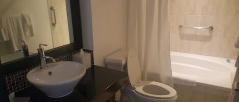 Ein Badezimmer mit Waschbecken, Toilette und Badewanne.