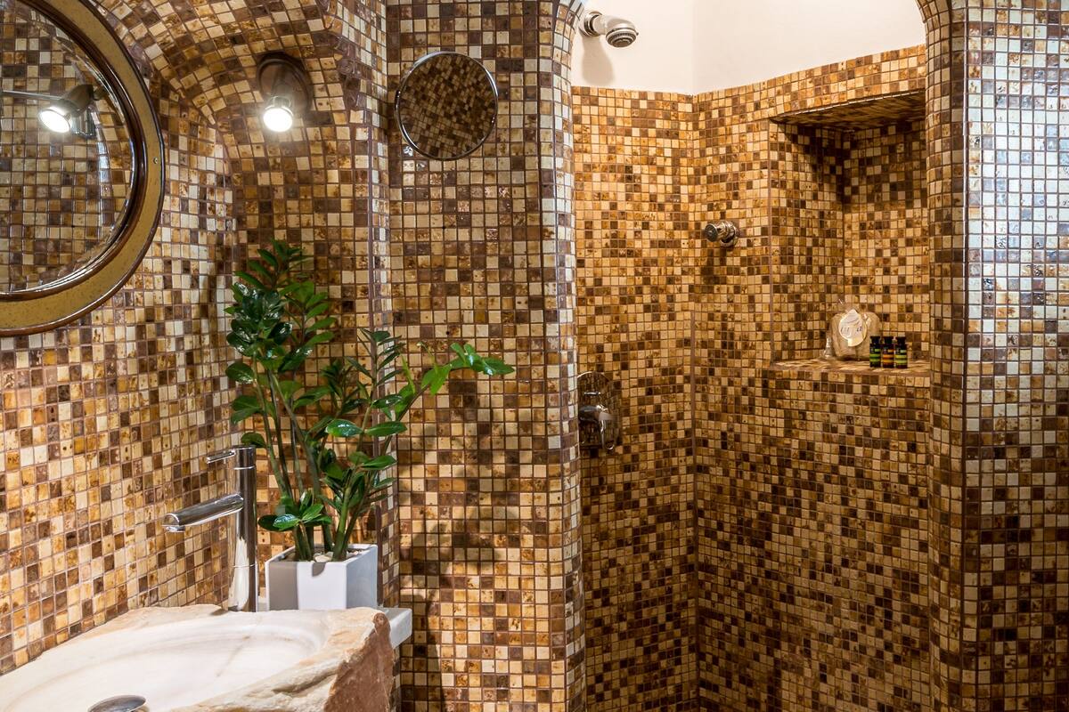 honeymoon suite (caldera view, indoor cave whirlpool) | bathroom | shower, rainfall showerhead, free toiletries, hair dryer